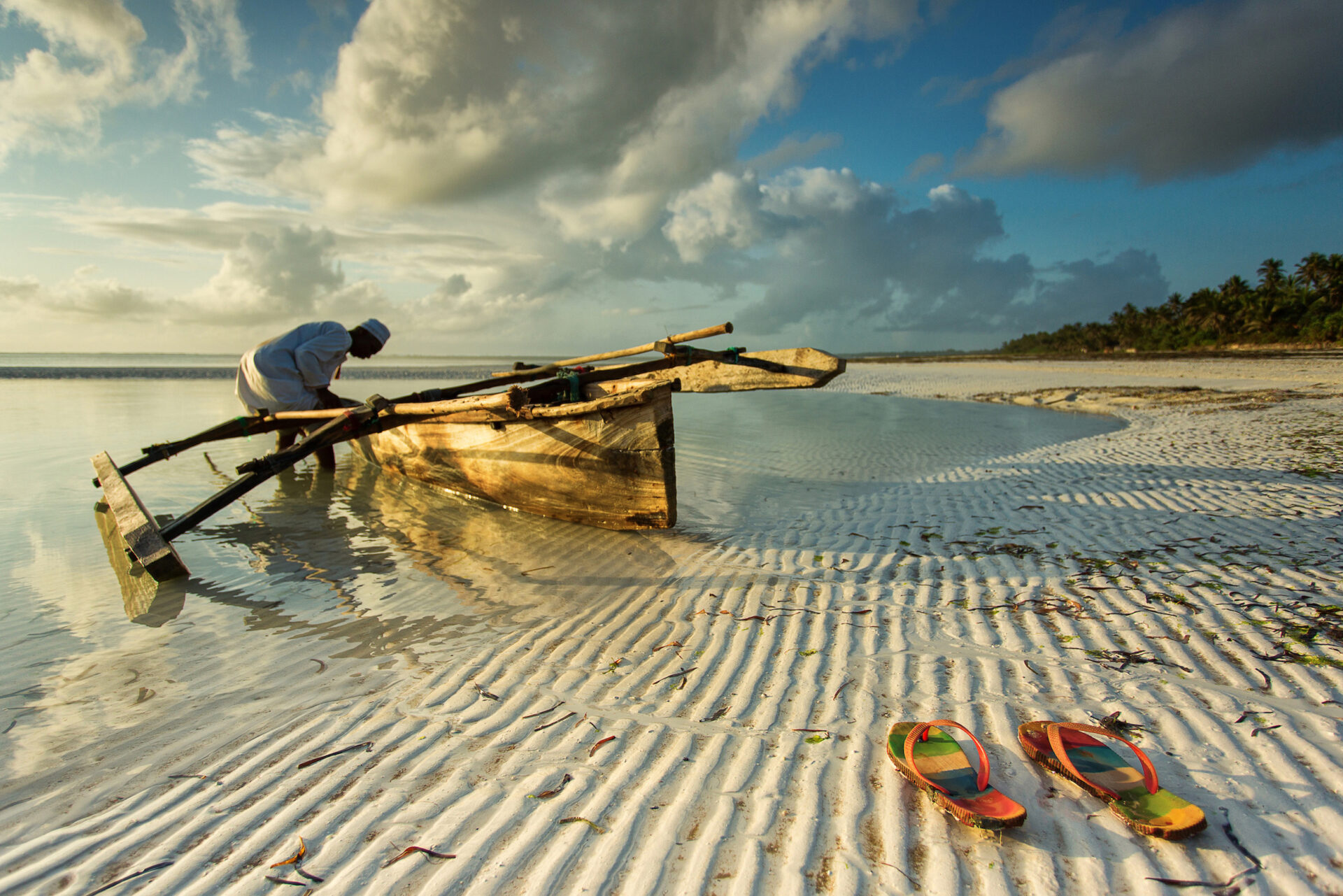 Traditional fisher boat in Zanzibar with people going to fish on low tide Strand på Zanzibar
