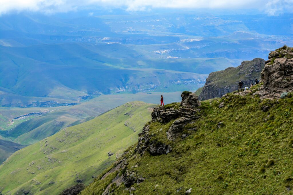 A lone hiker staring out towards the vast hill lands of Drakensberg, South Africa